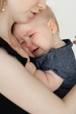 Ein Baby weint am Arm seiner Mutter.